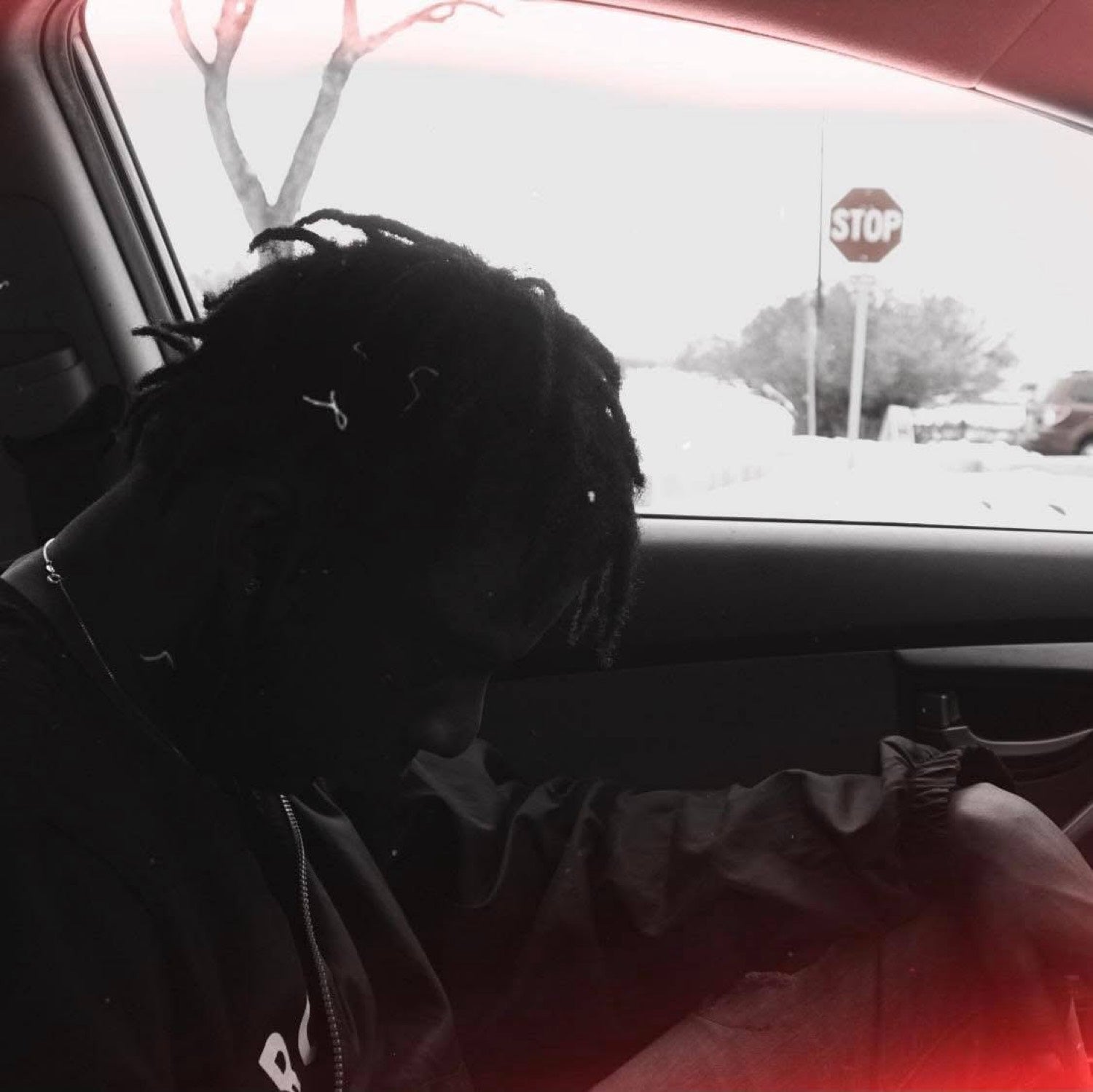 Kydale Outley in a car at dusk, a stop sign beyond the window.